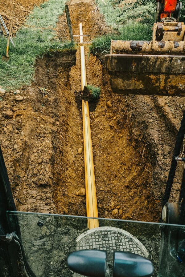 Die Firma Zemp Leitungsbau verlegt eine Leitung in einem langen Graben