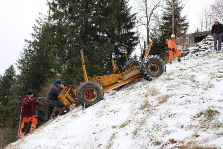Mehrere Mitarbeiter der Firma Zemp Leitungs- und Tiefbau GmbH arbeiten entschlossen auf dem schneebedeckten Feld daran, eine Ersatzwasserleitung im Boden zu pflügen.